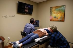 Pregnant woman getting an ultrasound by Dr. Mathers